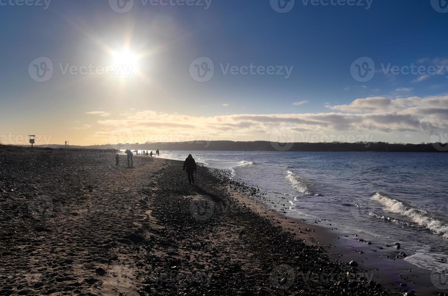 sagome di persone che parlano una passeggiata su una soleggiata spiaggia del Mar Baltico in Germania. foto