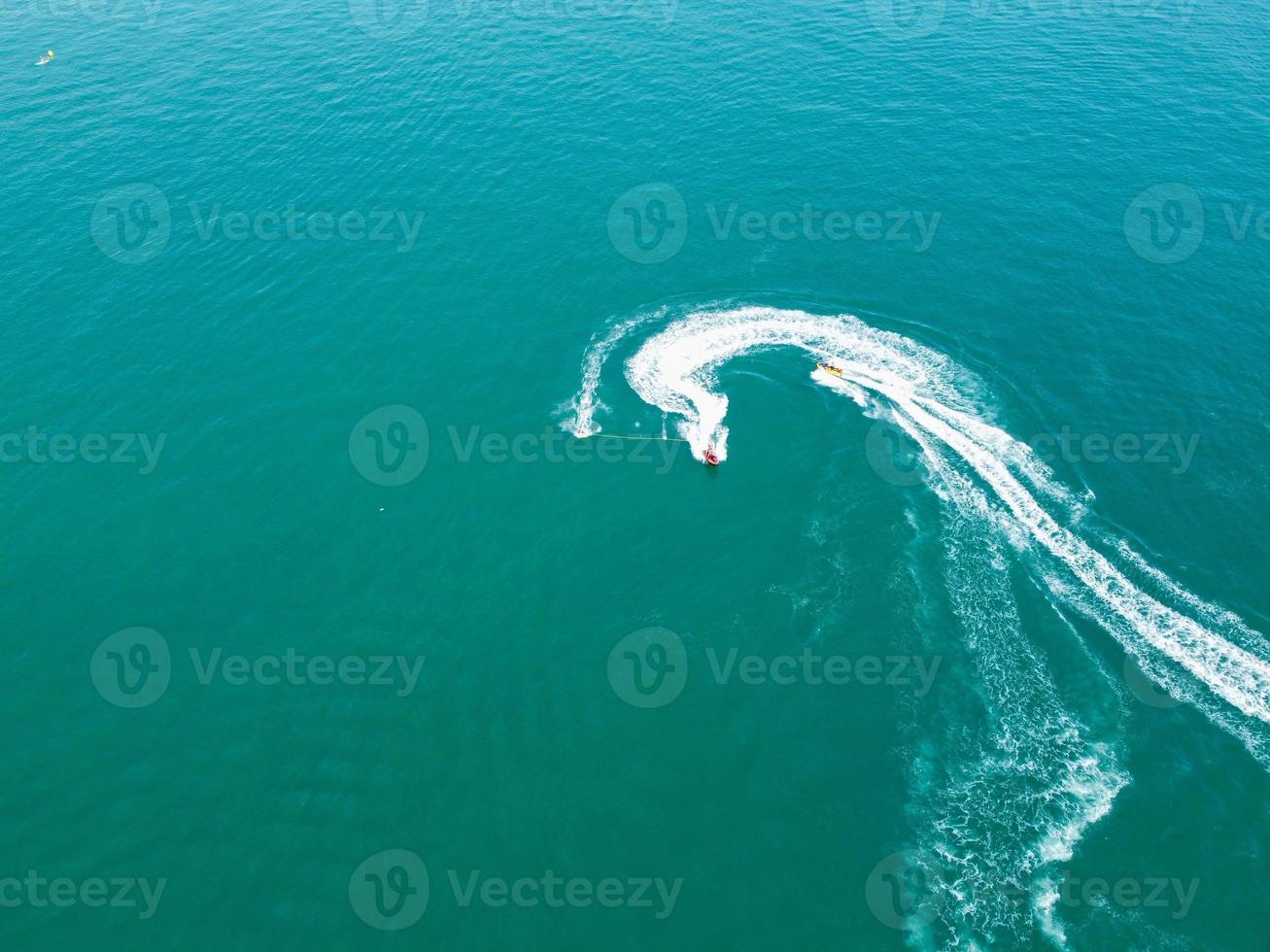 riprese ad alto angolo e vista aerea dell'oceano con barche ad alta velocità, le persone si divertono e si godono il clima più caldo a Bournemouth Beach, di fronte al mare dell'Inghilterra, Regno Unito. foto