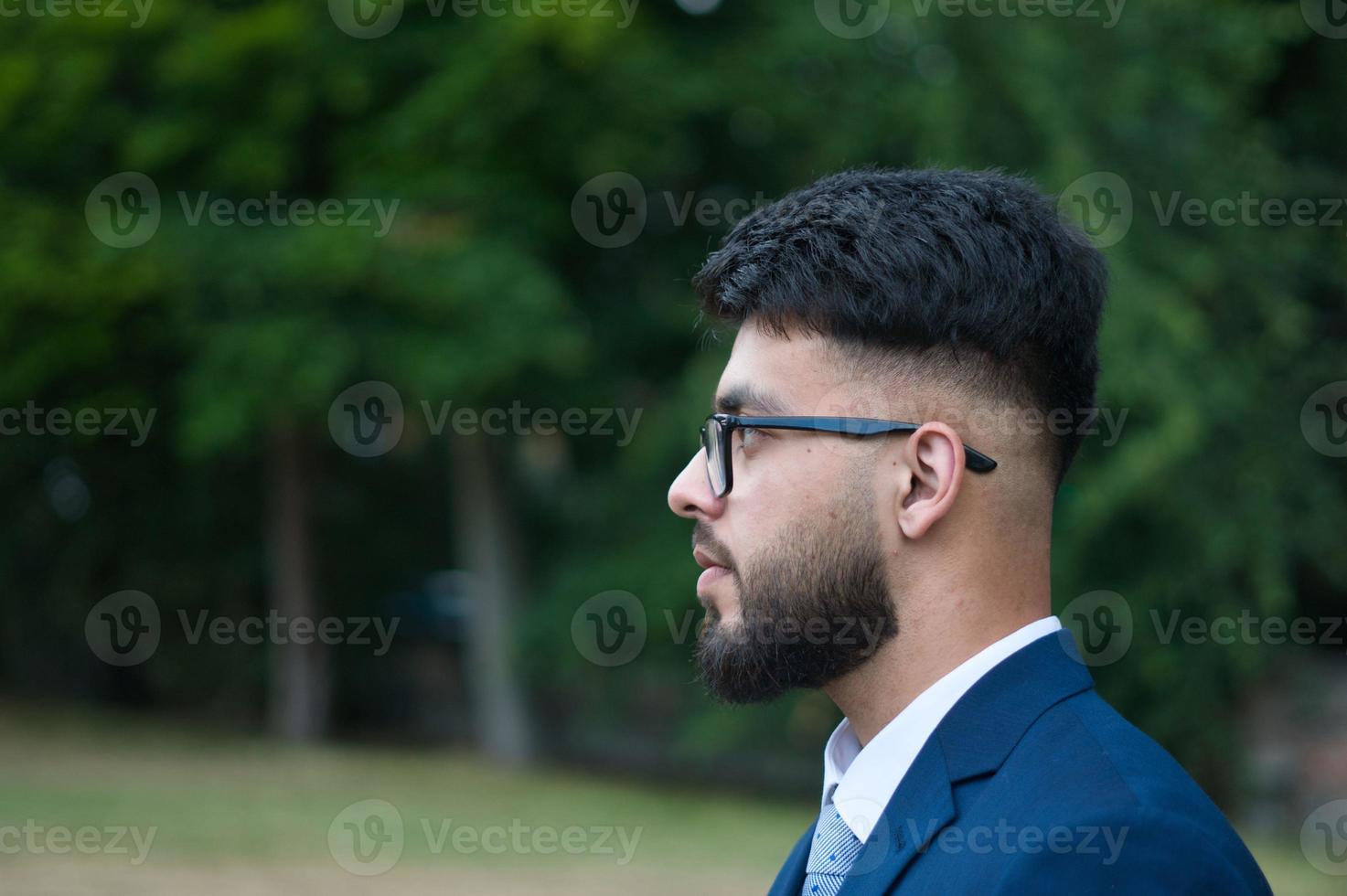 il giovane uomo d'affari sta posando al parco locale di luton inghilterra uk foto