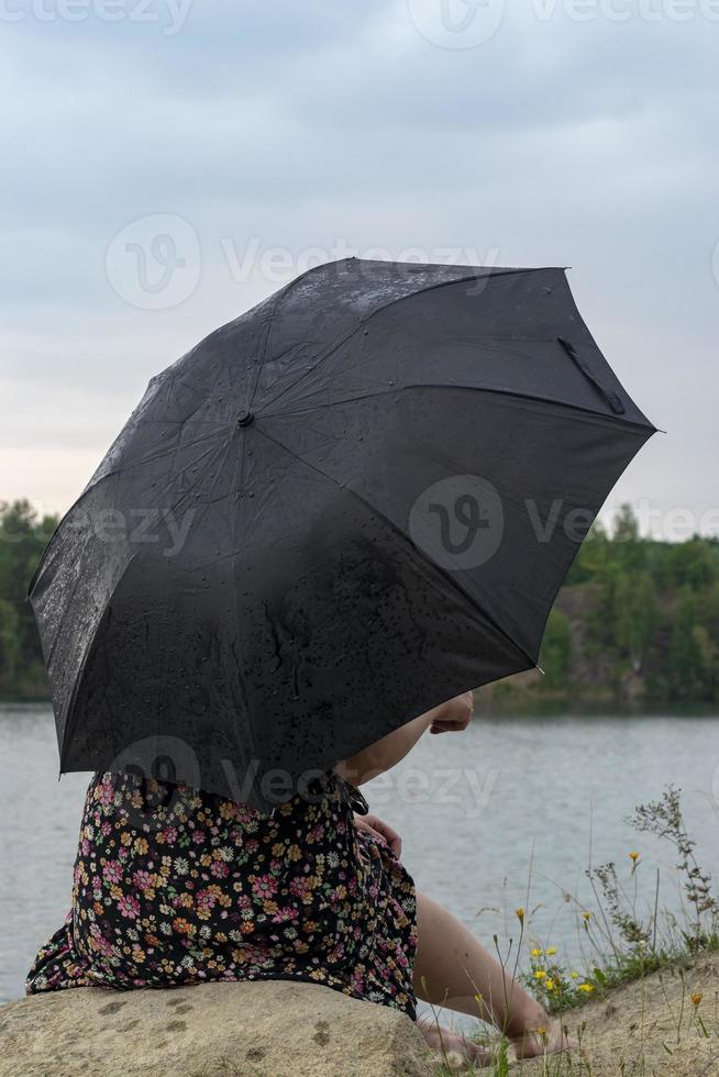 ragazza con un ombrello in tempo nuvoloso. foto
