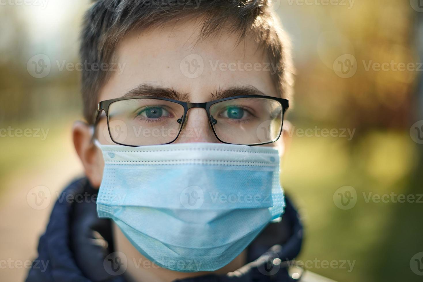 ragazzo con gli occhiali e in maschera medica sul concetto di assistenza sanitaria di strada. foto