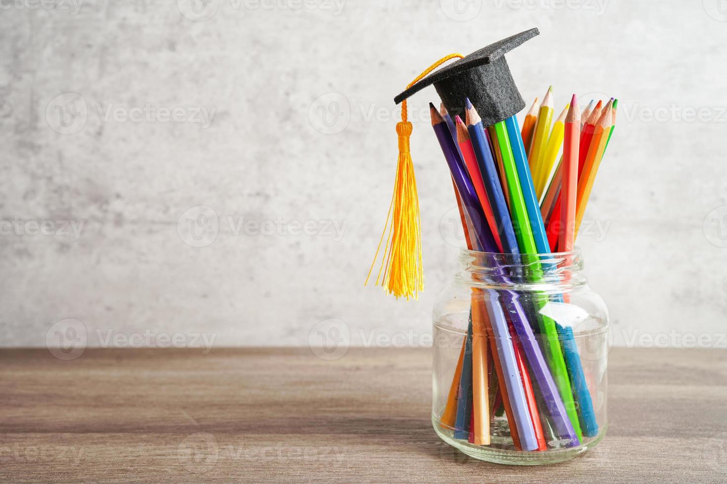 cappello di laurea con matite colorate sul libro con spazio di copia, apprendimento del concetto di istruzione universitaria. foto