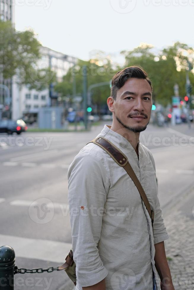 vita di città - bell'uomo in piedi accanto a una strada nelle ore pomeridiane foto