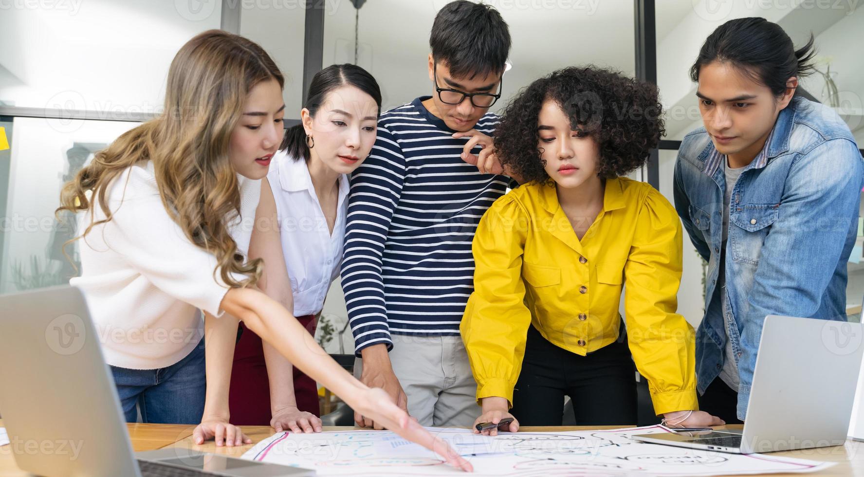 gruppo di giovani uomini d'affari creativi asiatici seri che si incontrano nella pianificazione del lavoro in ufficio moderno e condividono idee foto