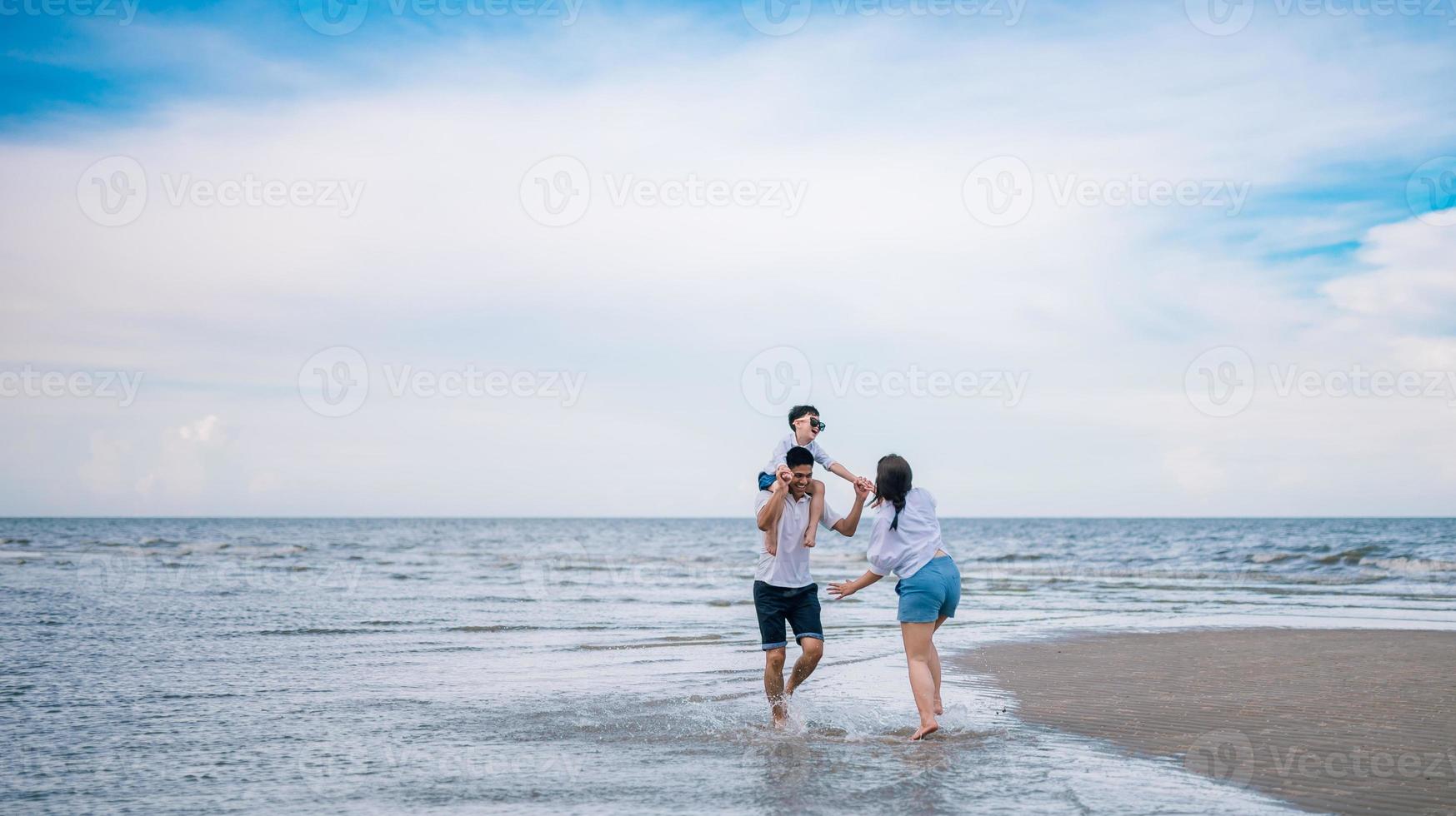 famiglia felice che salta sulla spiaggia foto