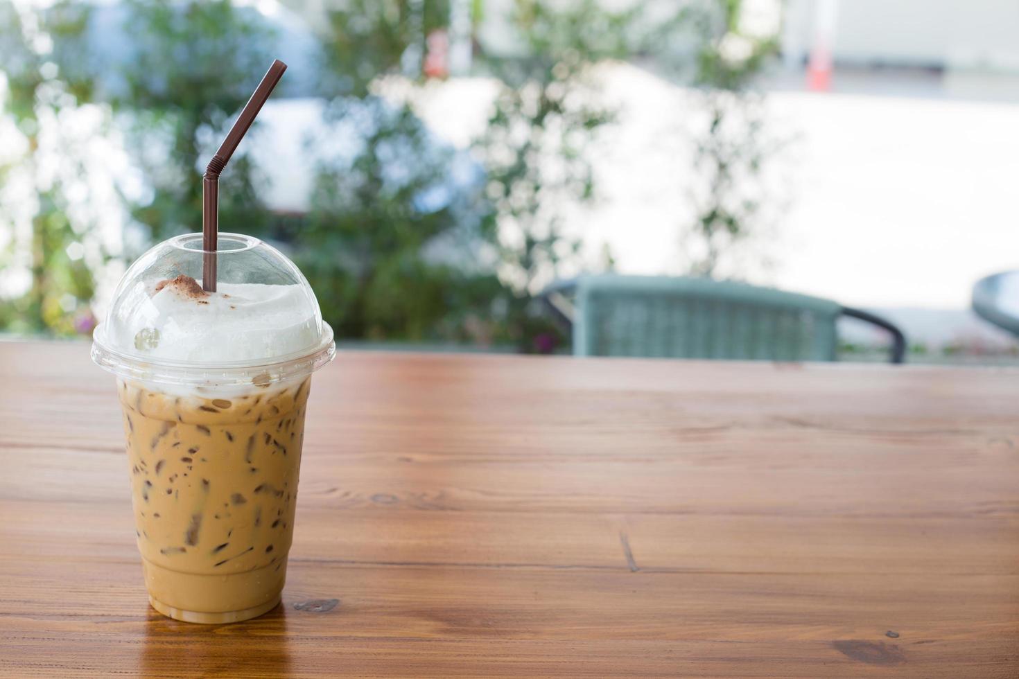 caffè freddo in vetro di plastica su tavola di legno. messa a fuoco selettiva. foto