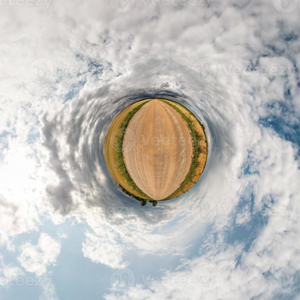 trasformazione del piccolo pianeta del panorama sferico a 360 gradi. vista aerea astratta sferica in campo in una bella serata con bellissime nuvole fantastiche. curvatura dello spazio. foto