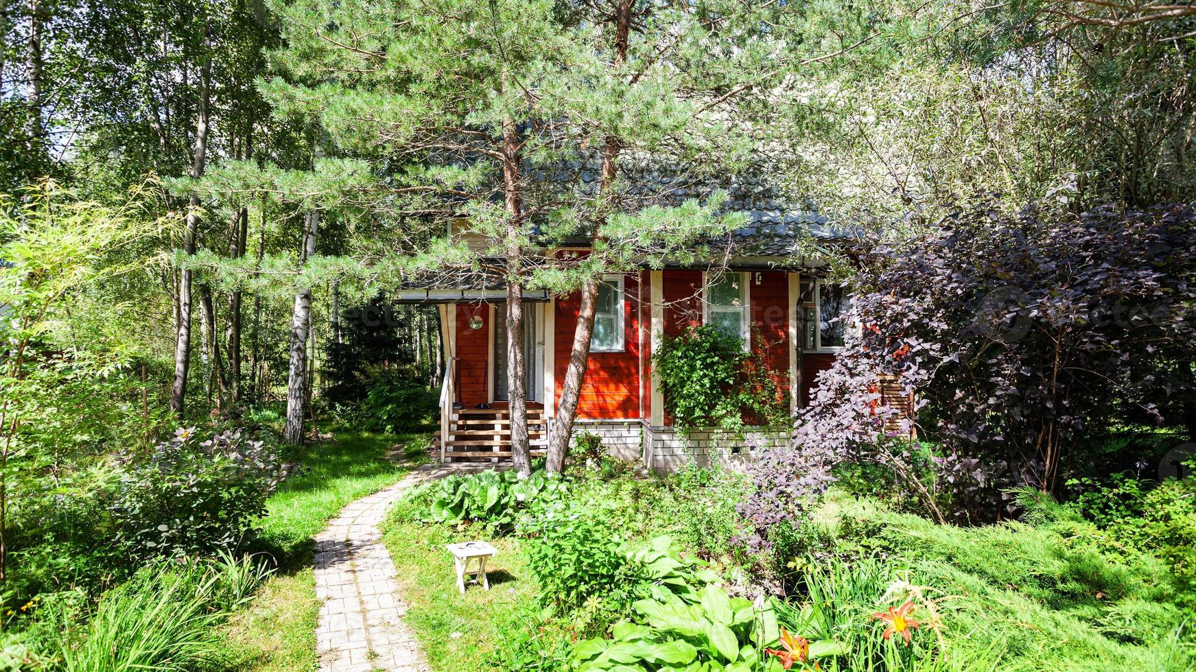 verde giardino ornamentale con casa di campagna in legno foto