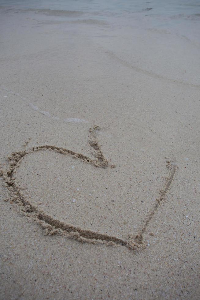 cuori disegnati sulla sabbia di una spiaggia foto