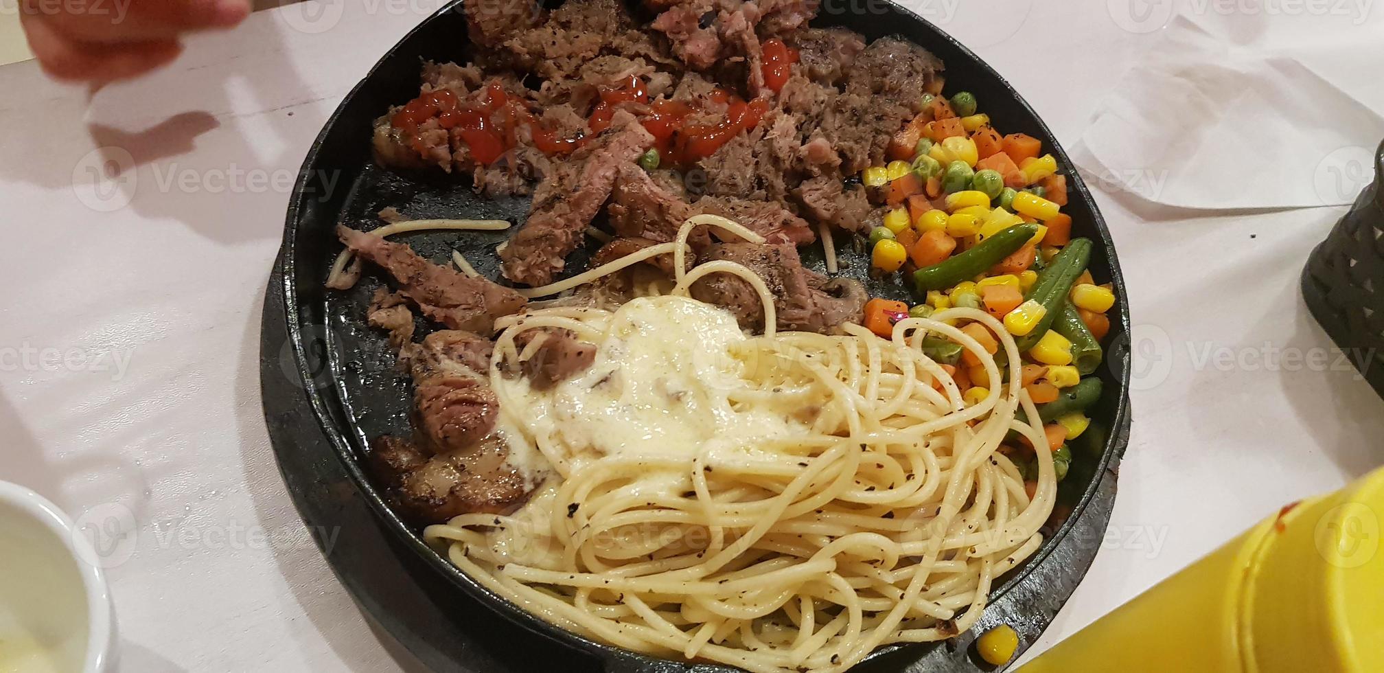 il miglior cibo del mondo bistecca di manzo insieme a patate fritte con deliziosa salsa di funghi e insalata placcata in un bellissimo piatto a strisce nere foto