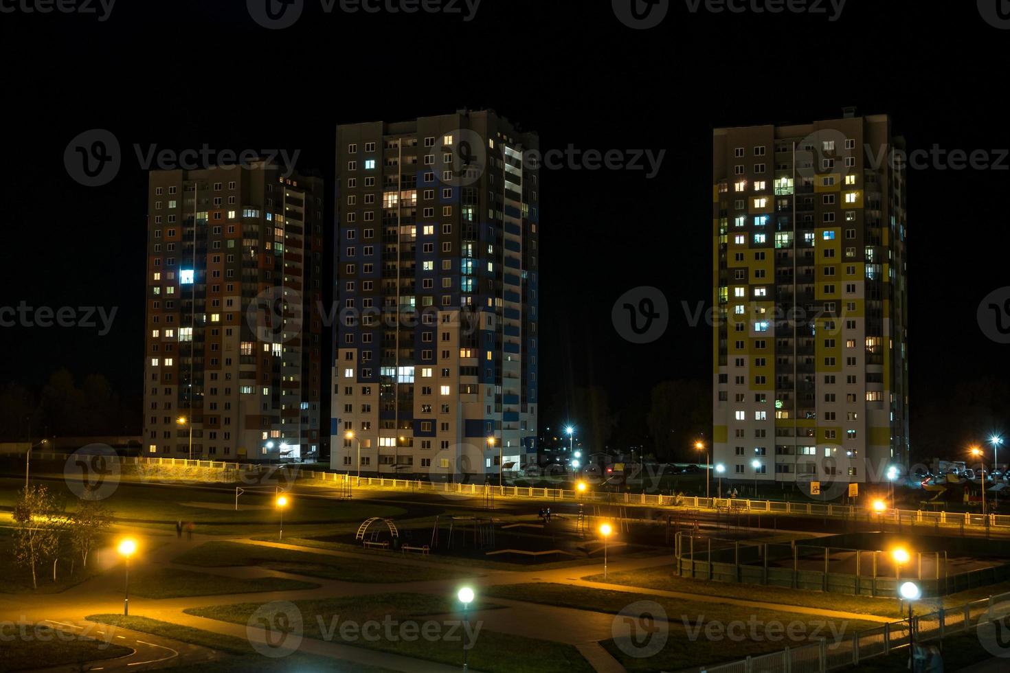 panorama notturno di luce nelle finestre di un edificio a più piani. vita in una grande città foto