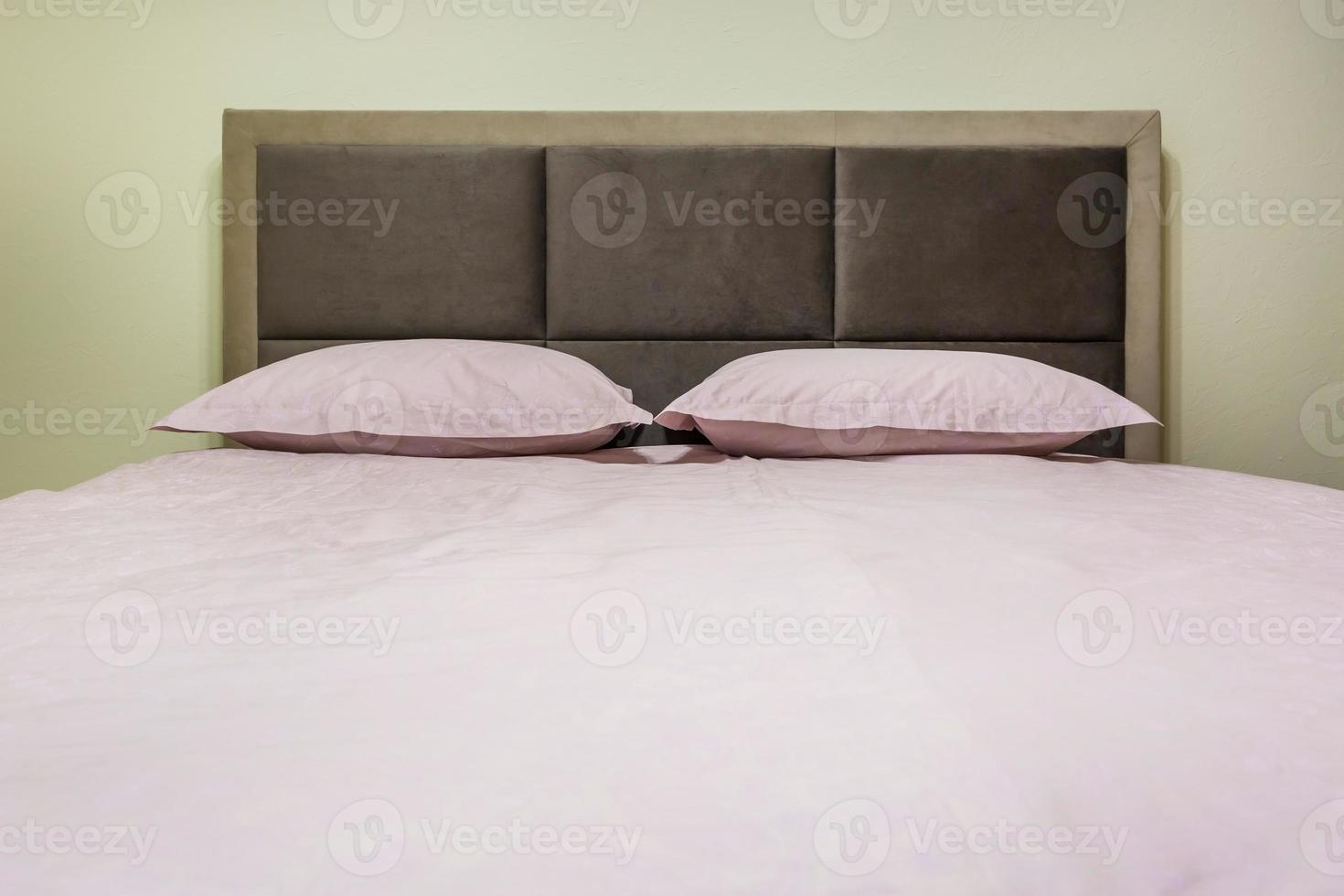 letto matrimoniale con cuscini all'interno della moderna camera da letto intima in soppalco in appartamenti in stile chiaro foto
