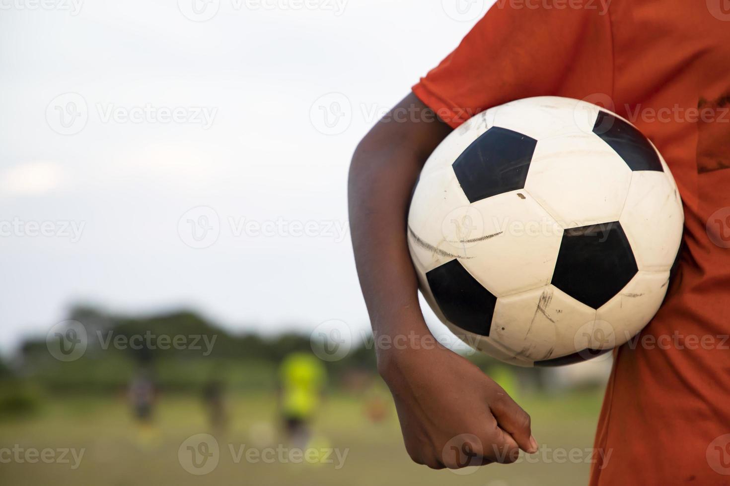 uomo che tiene un pallone da calcio sul campo da gioco foto