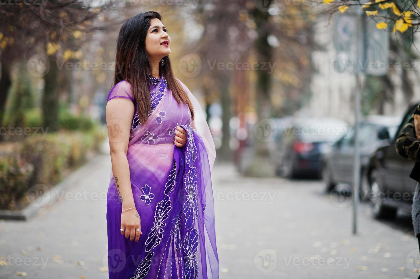 ragazza indù indiana al tradizionale saree viola poste in autunno street. foto