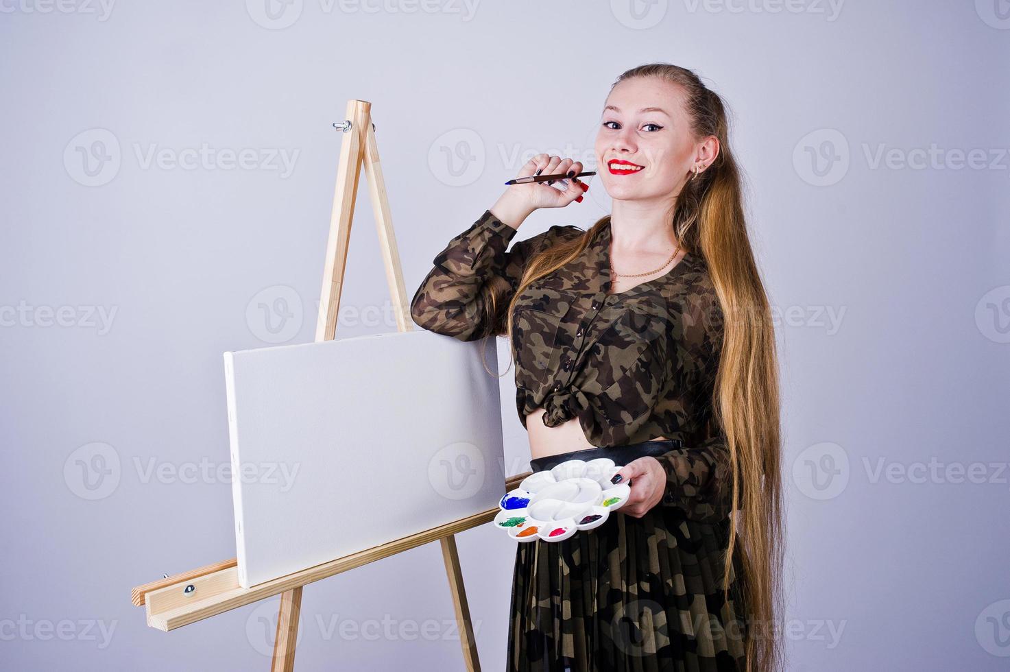 bella donna artista pittore con spazzole e tela a olio in posa in studio isolato su bianco. foto