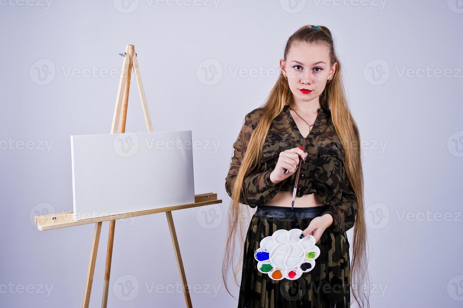 bella donna artista pittore con spazzole e tela a olio in posa in studio isolato su bianco. foto