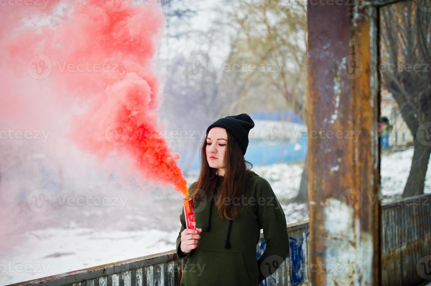 giovane ragazza con una bomba fumogena di colore rosso in mano. foto