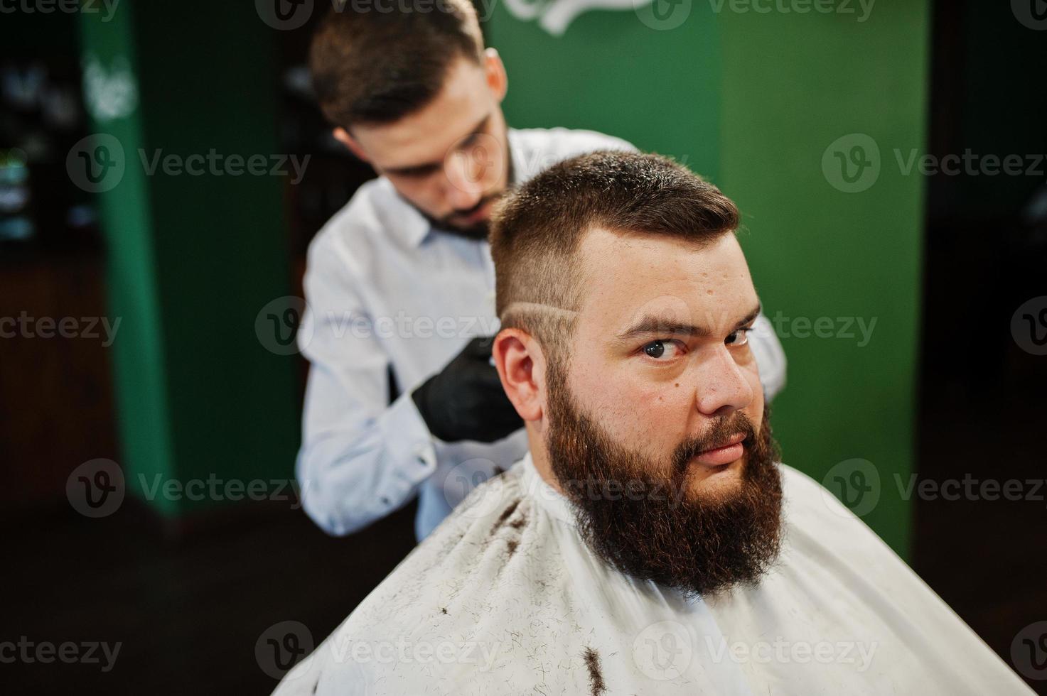 bell'uomo barbuto dal barbiere, barbiere al lavoro. foto