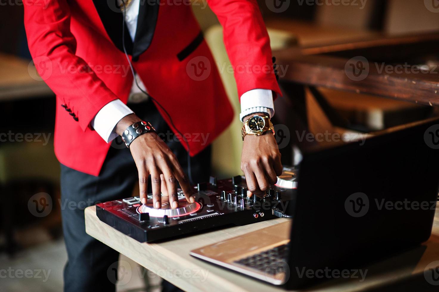 mani di moda uomo afroamericano modello dj al vestito rosso con controller dj. foto