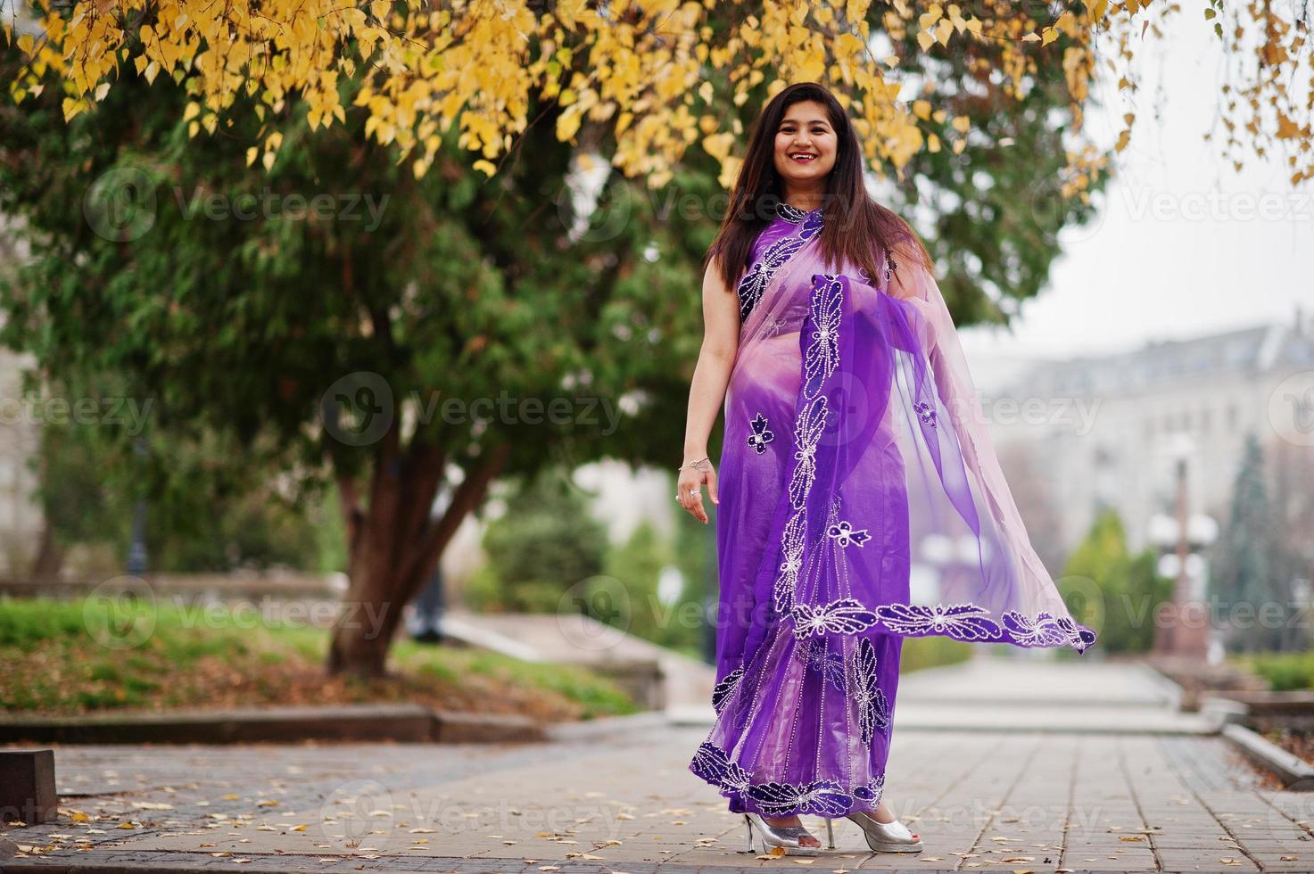 ragazza indù indiana al tradizionale saree viola poste in autunno street. foto