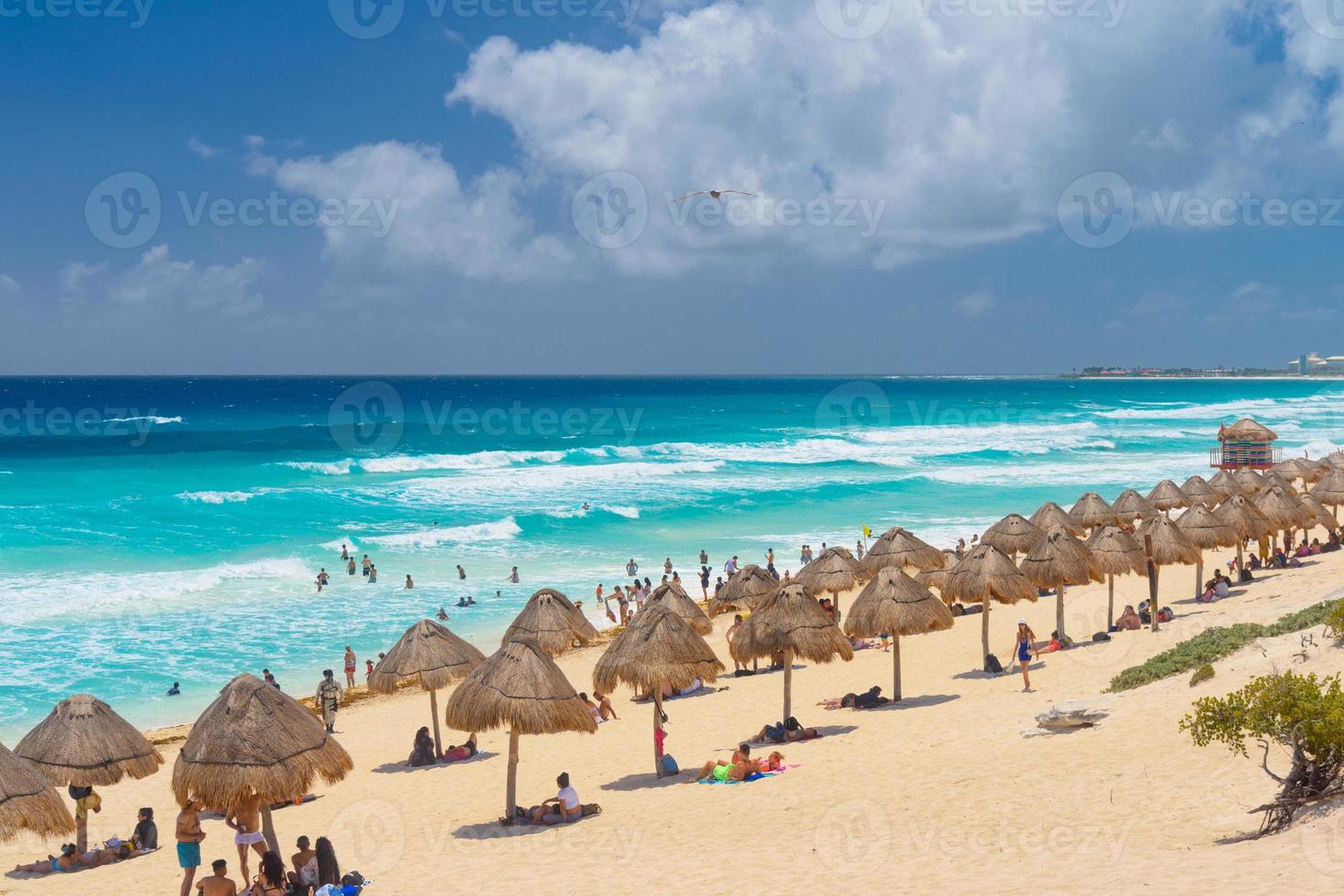 ombrelloni su una spiaggia sabbiosa con acqua azzurra in una giornata di sole vicino a cancun, in messico foto