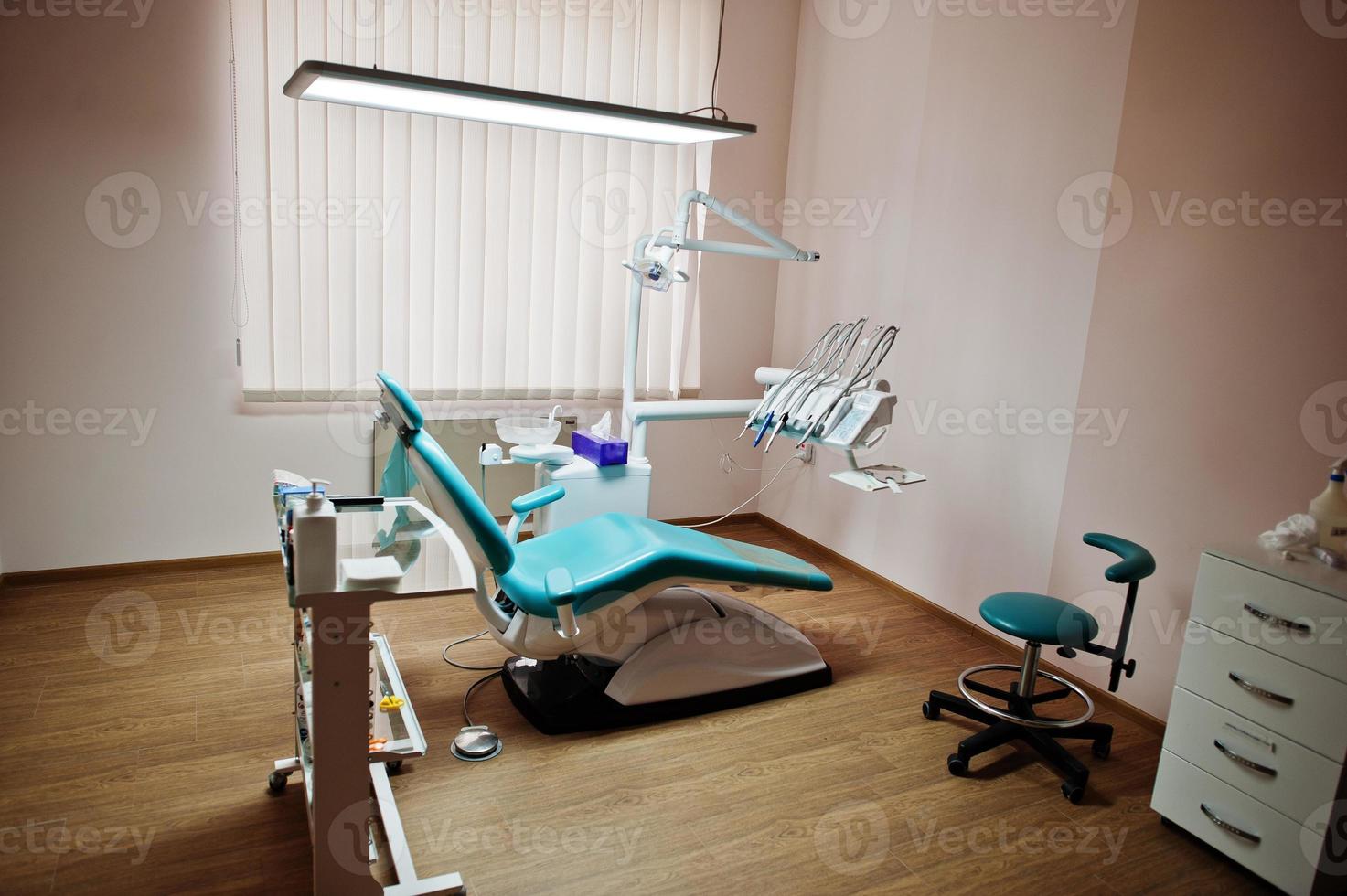 poltrona odontoiatrica di dentisti in blu con luce medica. studio dentistico moderno. foto
