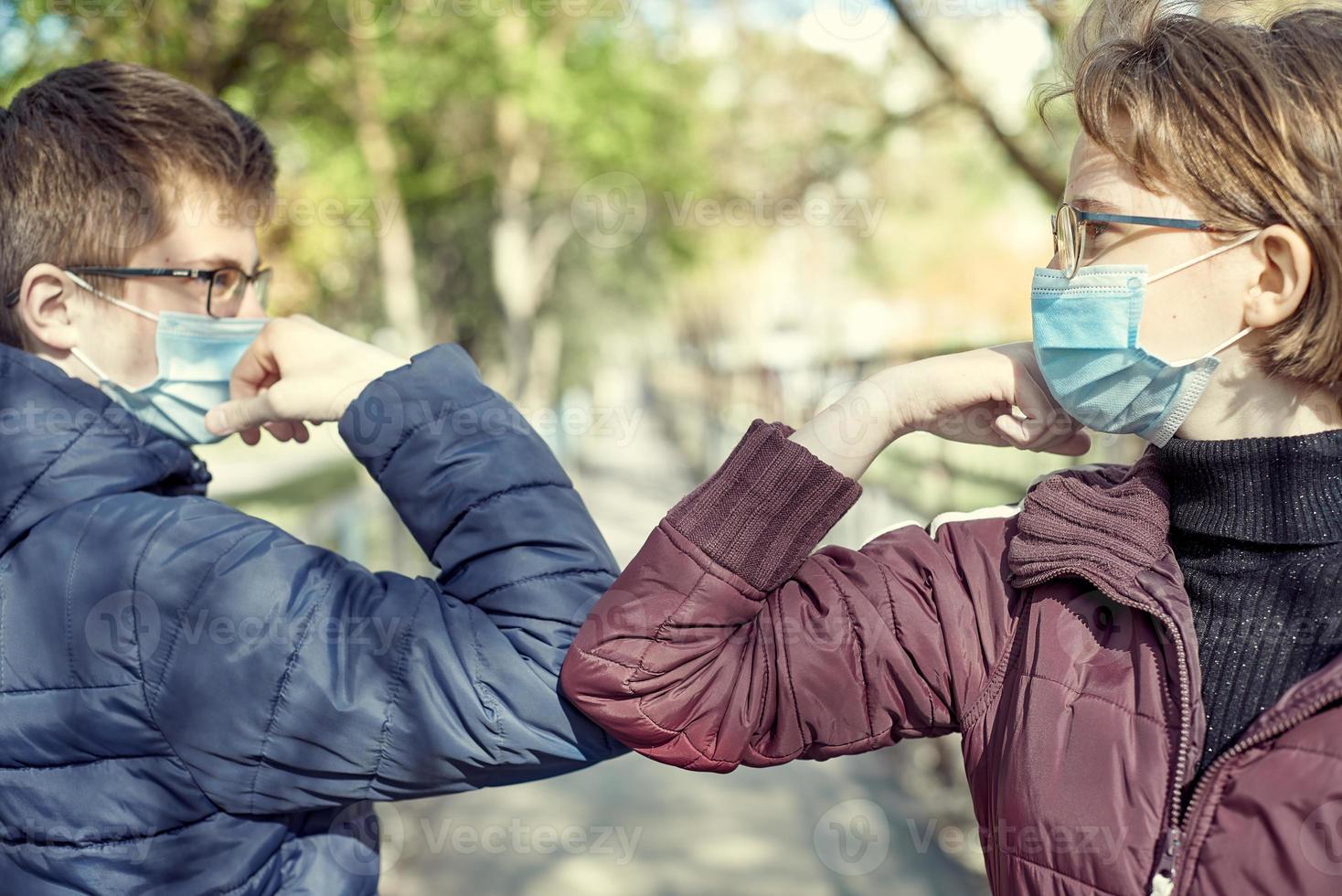 due persone urtano i gomiti per evitare il coronavirus all'aperto. amici che dimostrano un nuovo modo di salutare durante l'epidemia di coronavirus. concetto di assistenza sanitaria. riduzione dei contatti. foto