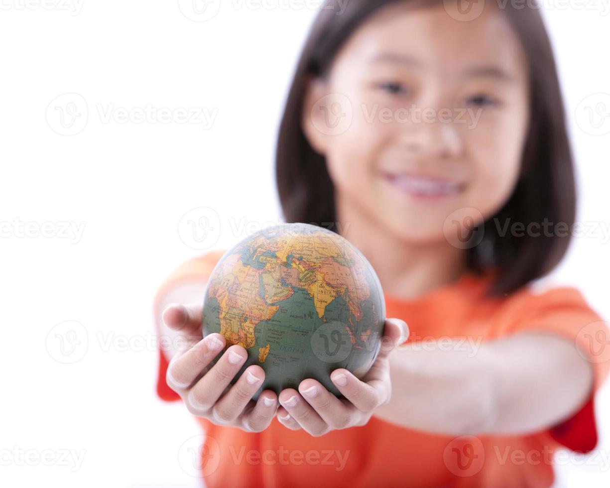 ragazza asiatica che tiene piccolo globo o terra foto