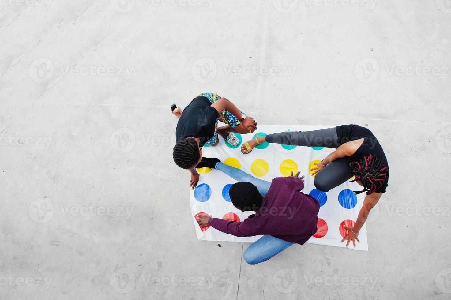 un gruppo di tre amici afroamericani gioca a twister all'aperto. foto