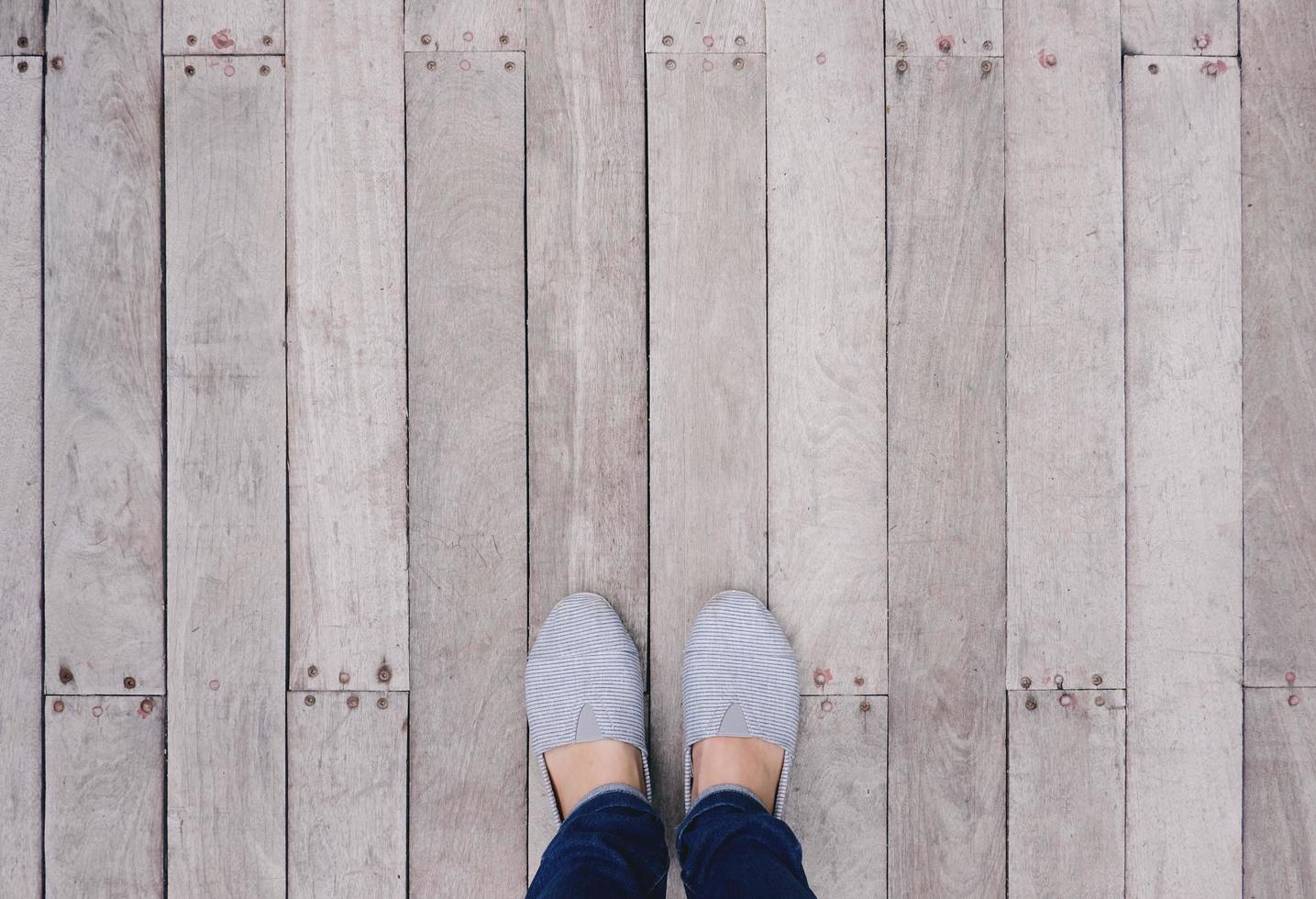 selfie di piedi e scarpe su sfondo pavimento in legno con spazio per la copia, vista dall'alto foto