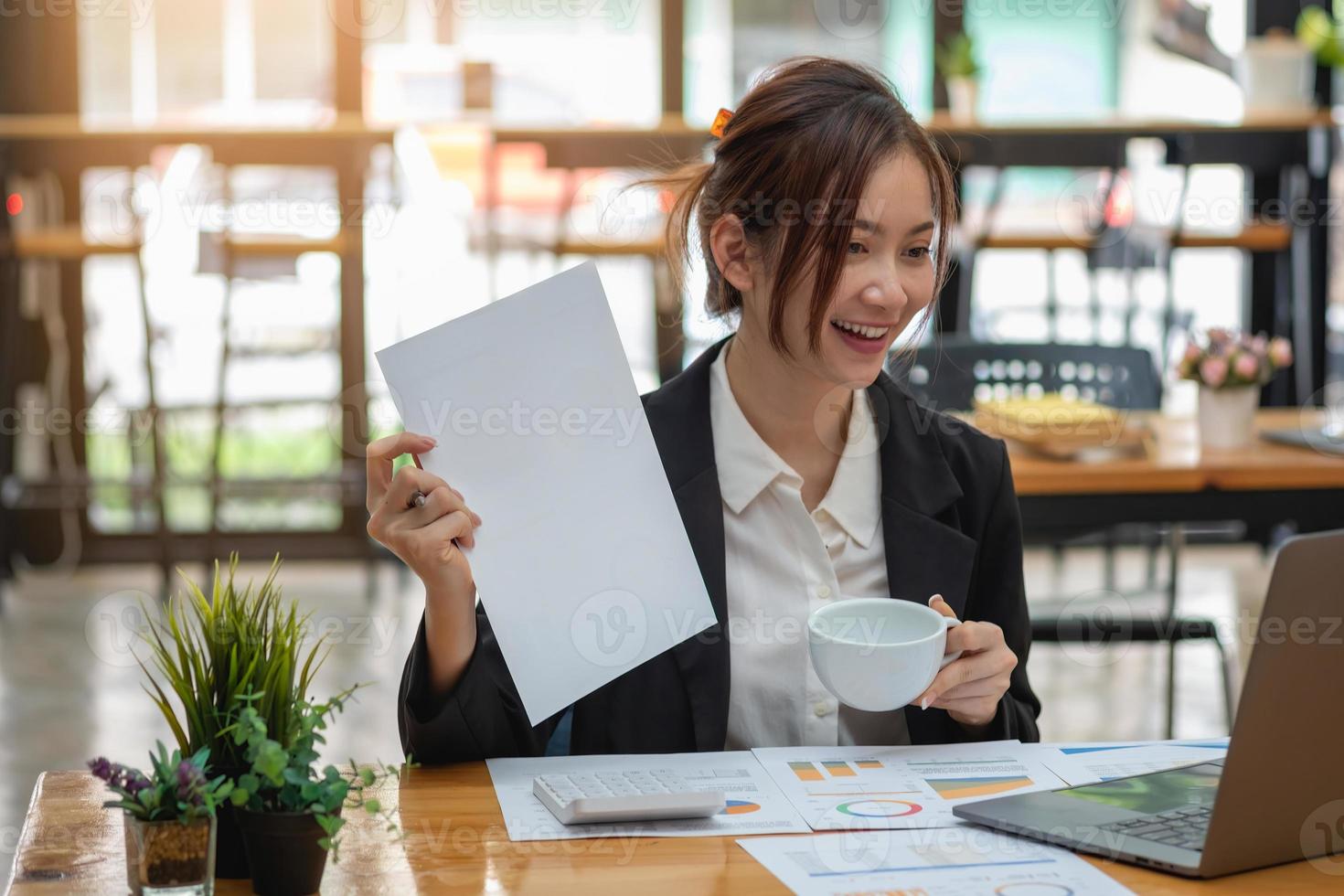 marketing, finanza, contabilità, pianificazione, donna d'affari che tiene una tazza di caffè analisi dei profitti della riunione online con statistiche del grafico utilizzare un laptop e una calcolatrice per calcolare il saldo aziendale. foto