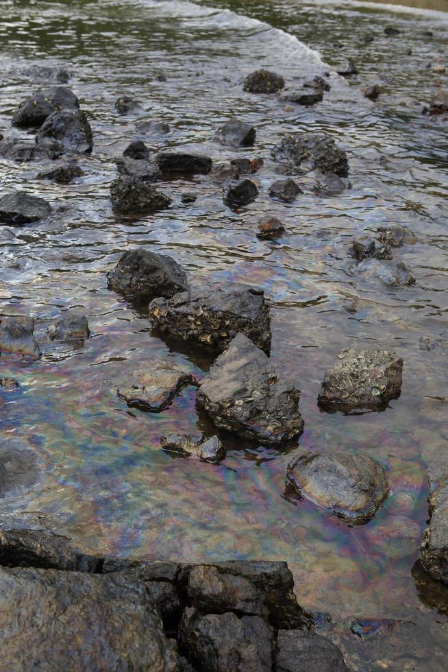 petrolio greggio in acqua di mare e riflesso arcobaleno foto