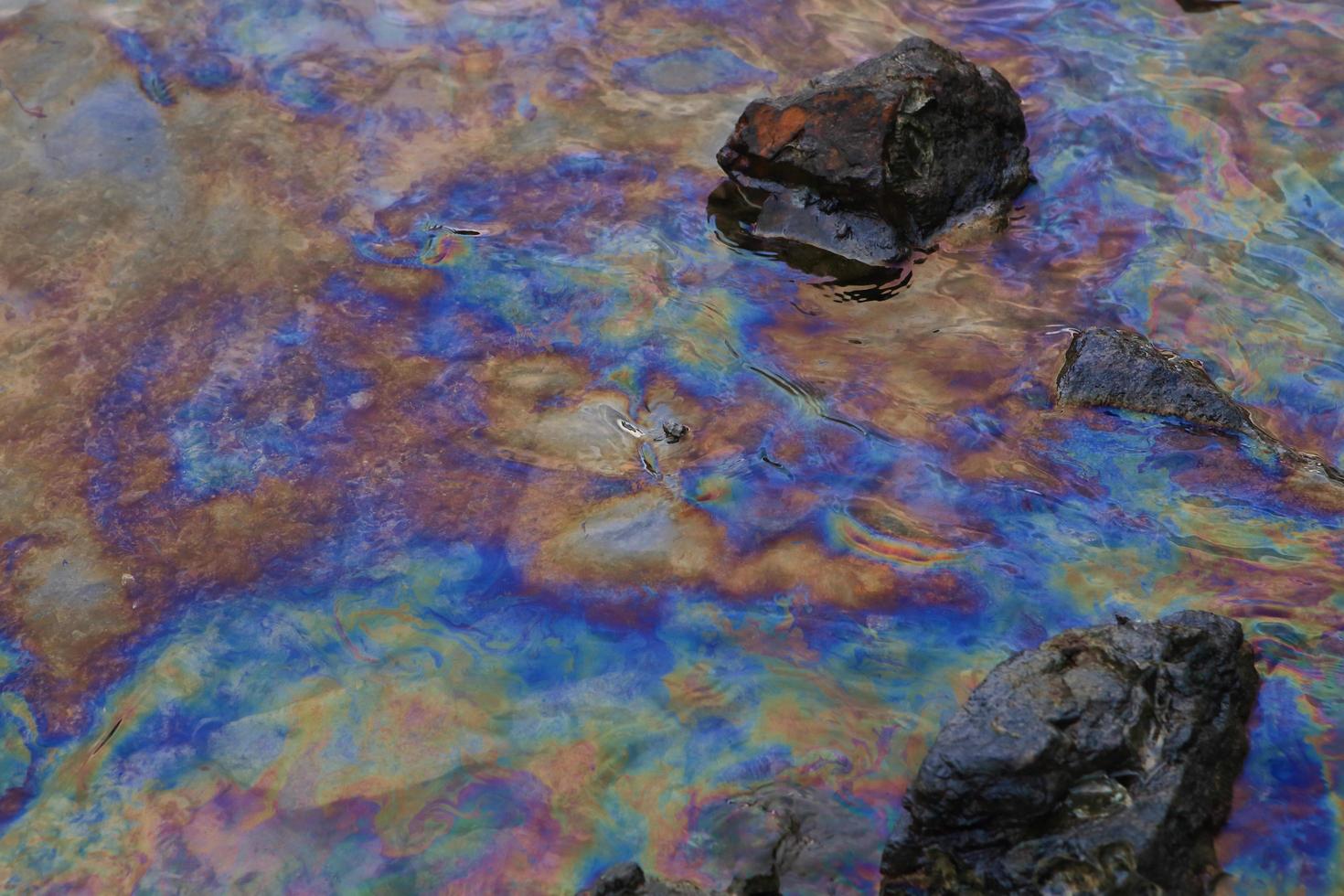 petrolio greggio in acqua di mare e riflesso arcobaleno foto