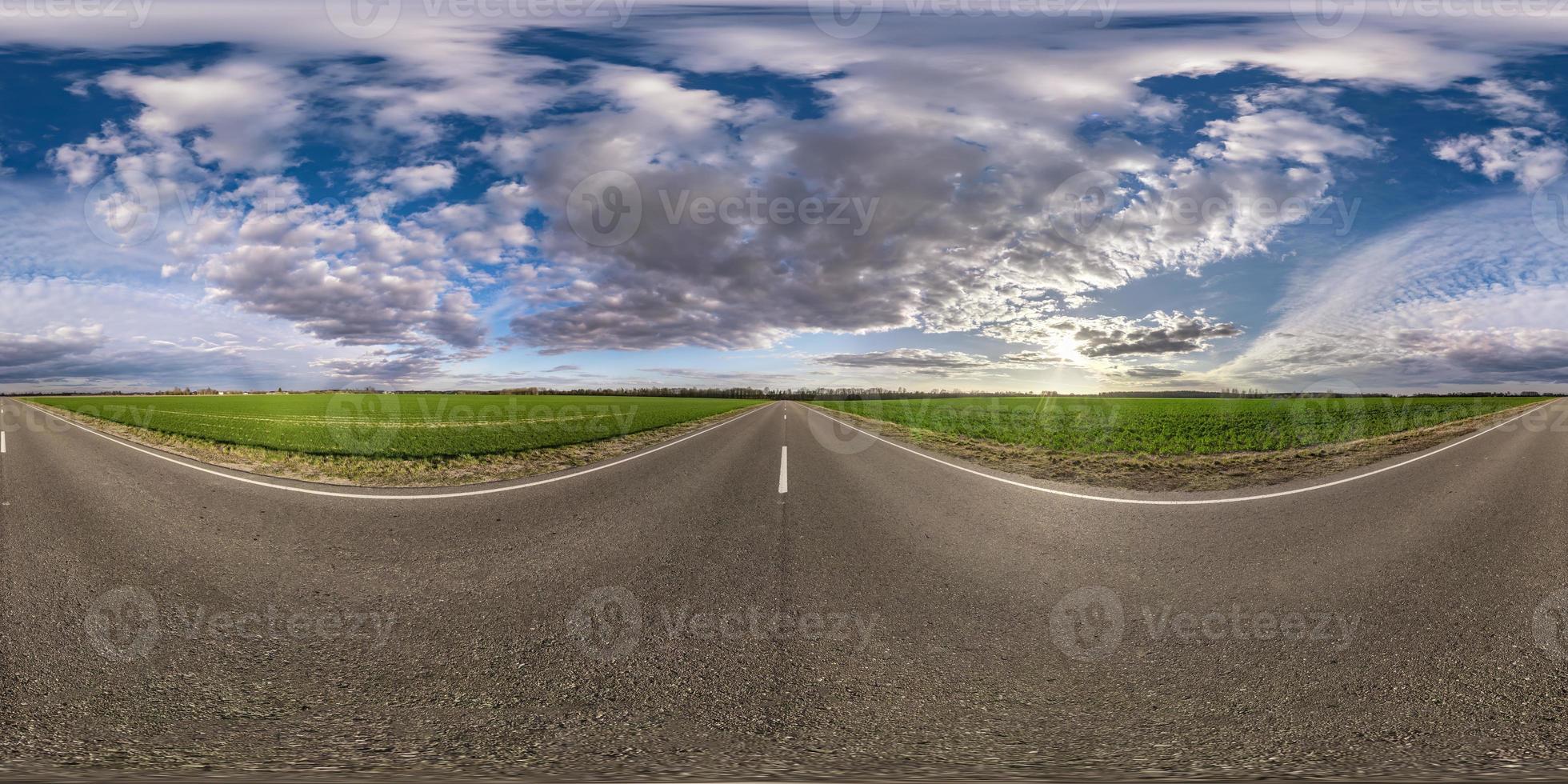 panorama sferico completo senza soluzione di continuità vista angolare a 360 gradi su strada asfaltata senza traffico tra i campi la sera prima del tramonto con cielo nuvoloso. Panorama a 360 gradi in proiezione equirettangolare, contenuto vr ar foto