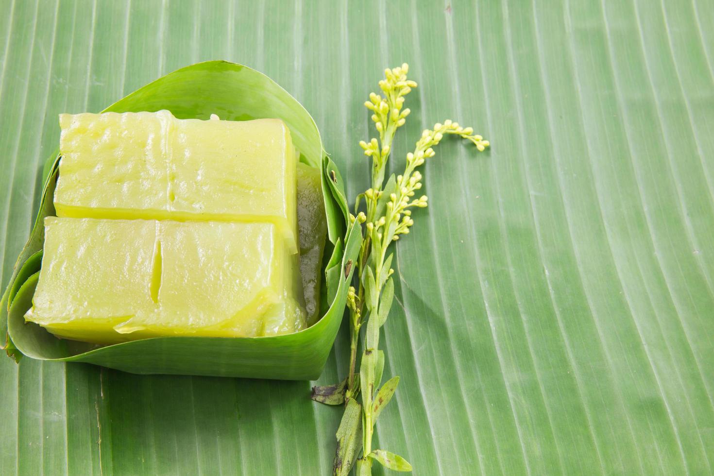 tipo di dolce tailandese, torta dolce multistrato kanom chan su foglia di banana con fiore di orchidea foto