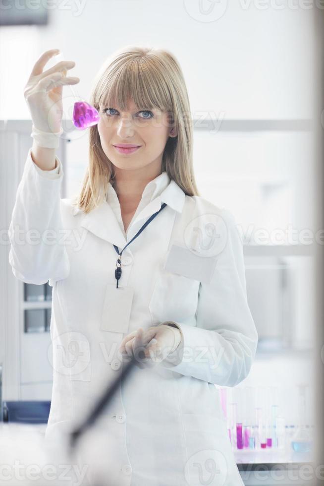 ricercatrice femminile che sorregge una provetta in laboratorio foto