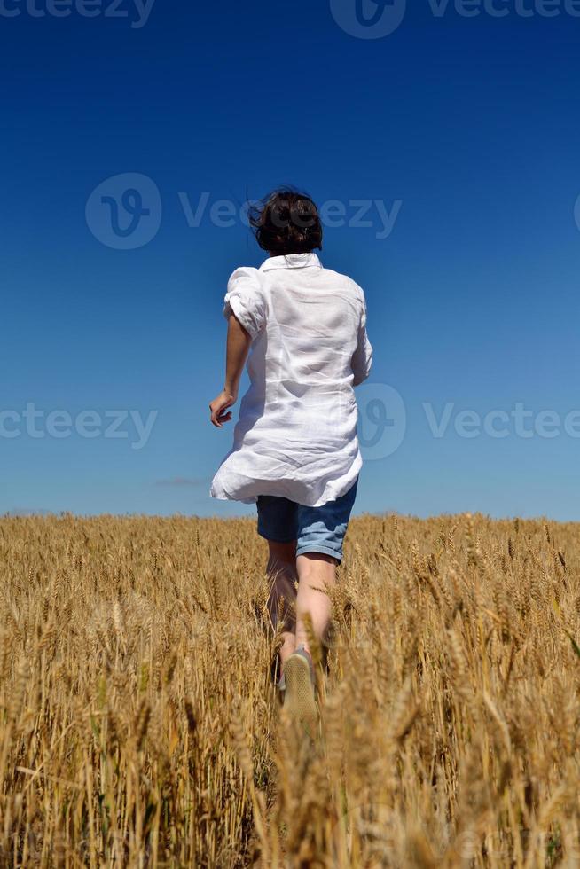 giovane donna nel campo di grano in estate foto