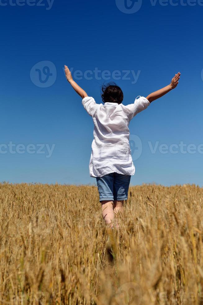 giovane donna nel campo di grano in estate foto