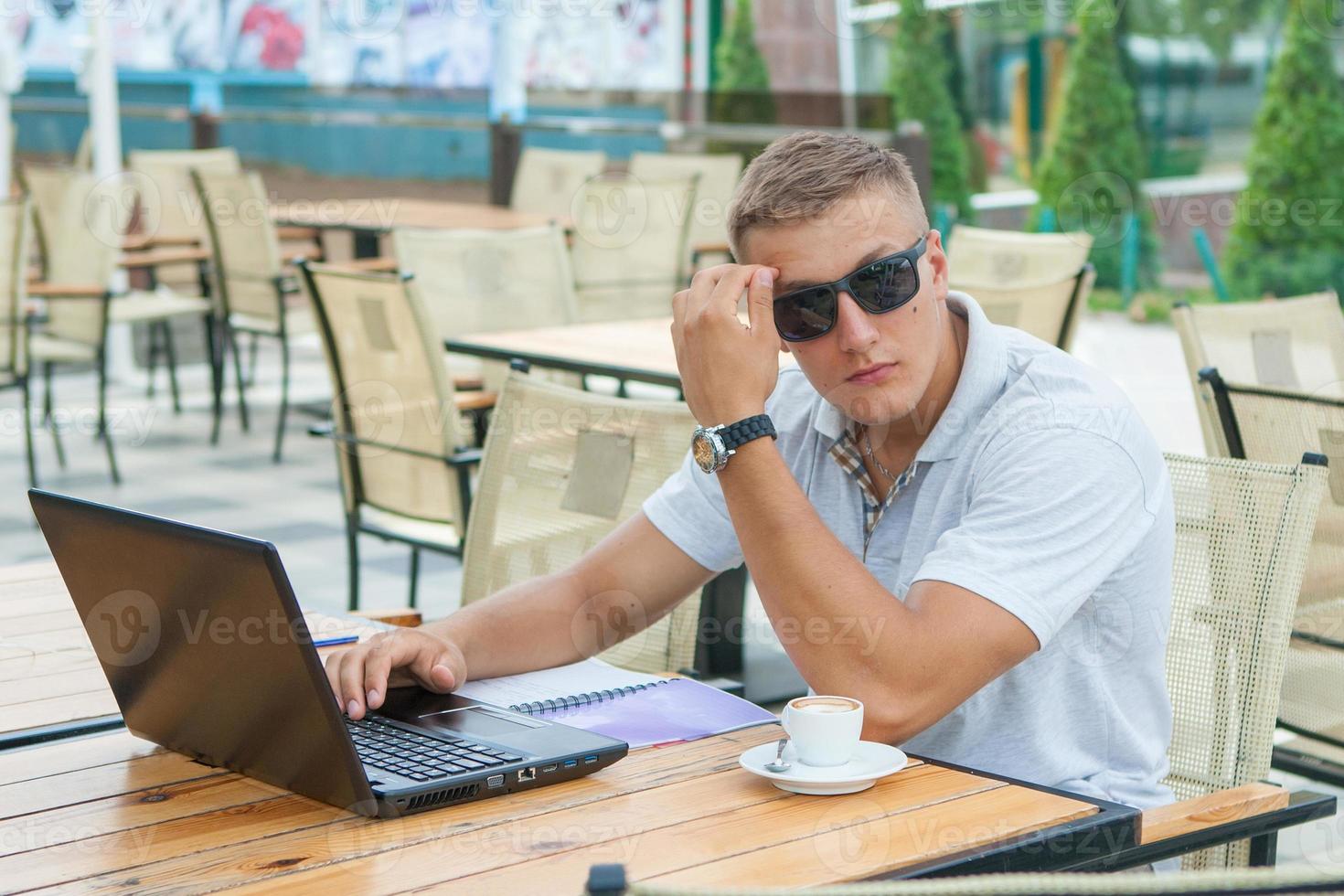 giovane seduto al caffè foto