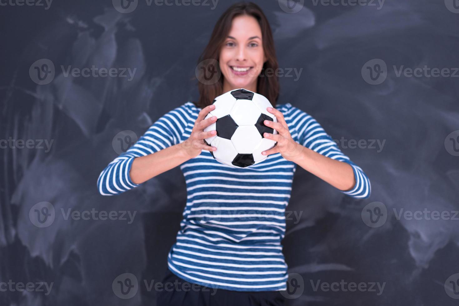 donna che tiene un pallone da calcio davanti al tavolo da disegno di gesso foto