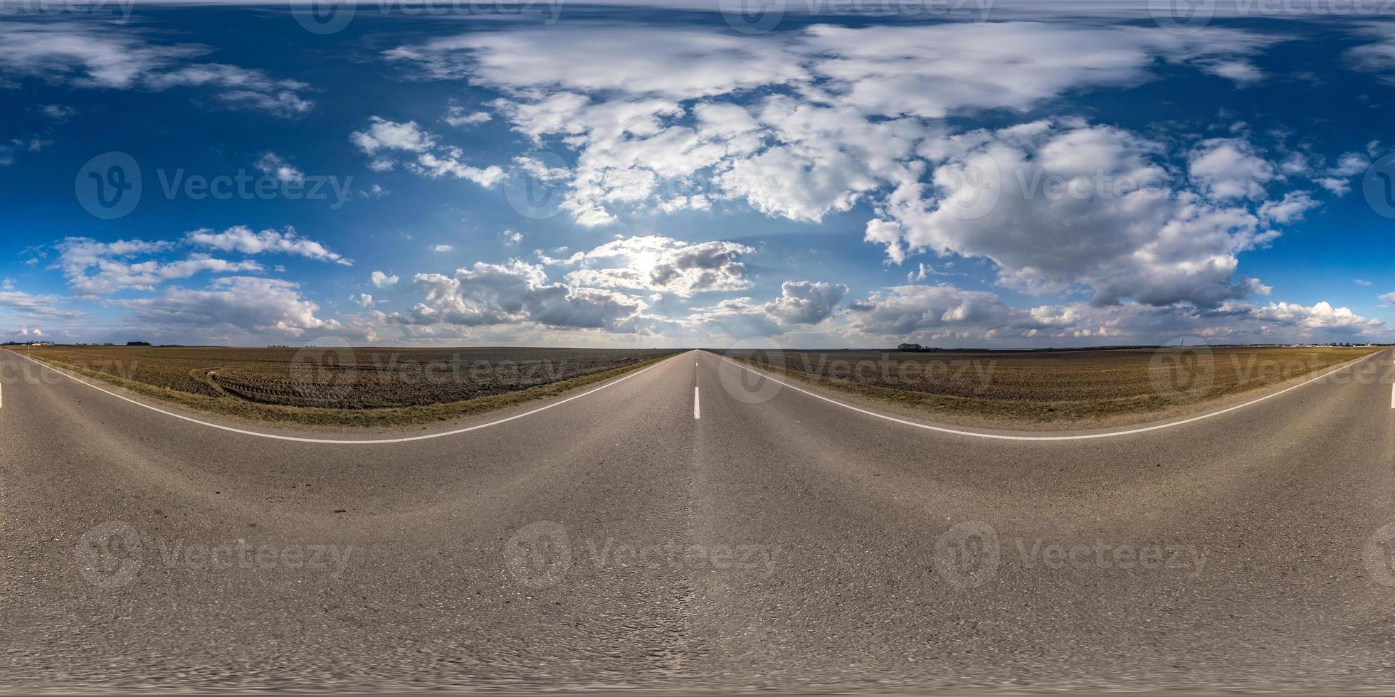 panorama sferico completo senza soluzione di continuità vista angolare a 360 gradi su strada asfaltata senza traffico tra i campi in una giornata primaverile con cielo nuvoloso. Panorama a 360 gradi in proiezione equirettangolare, contenuto vr ar foto