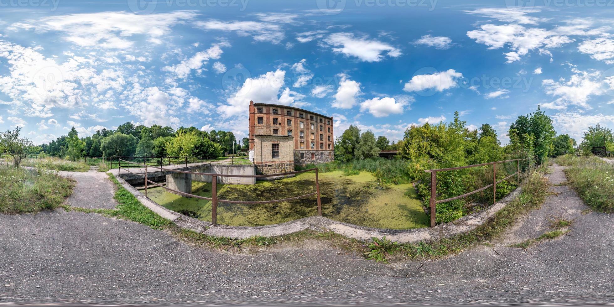 panorama hdri sferico completo senza soluzione di continuità vista angolare a 360 gradi vicino alla diga del vecchio mulino ad acqua in proiezione equirettangolare, contenuto di realtà virtuale vr ar. produzione di energia eolica. pura energia verde. foto