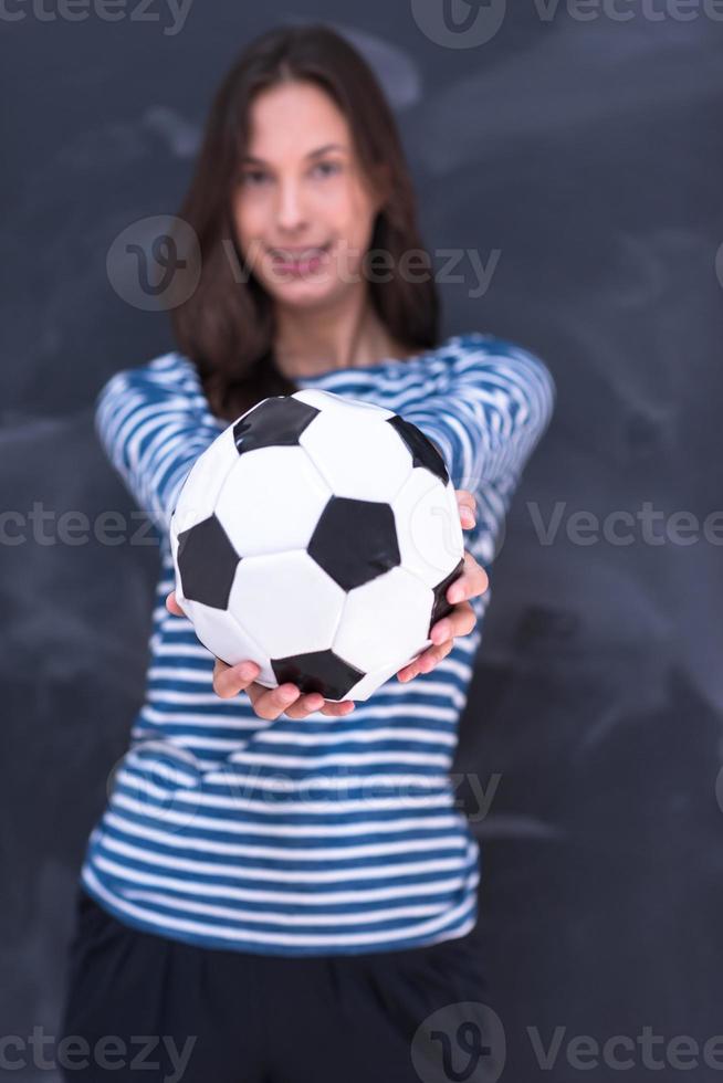 donna che tiene un pallone da calcio davanti al tavolo da disegno di gesso foto