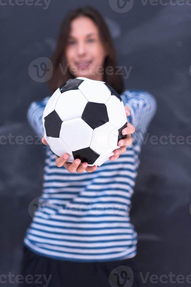 donna che tiene un pallone da calcio davanti al tavolo da disegno di gesso foto