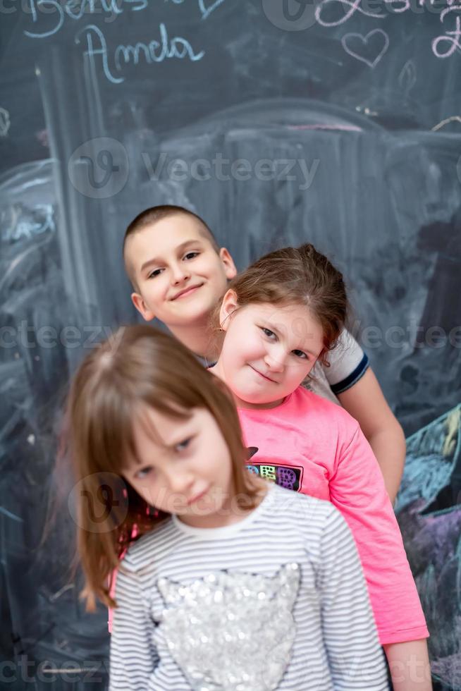 gruppo di bambini in piedi davanti alla lavagna foto