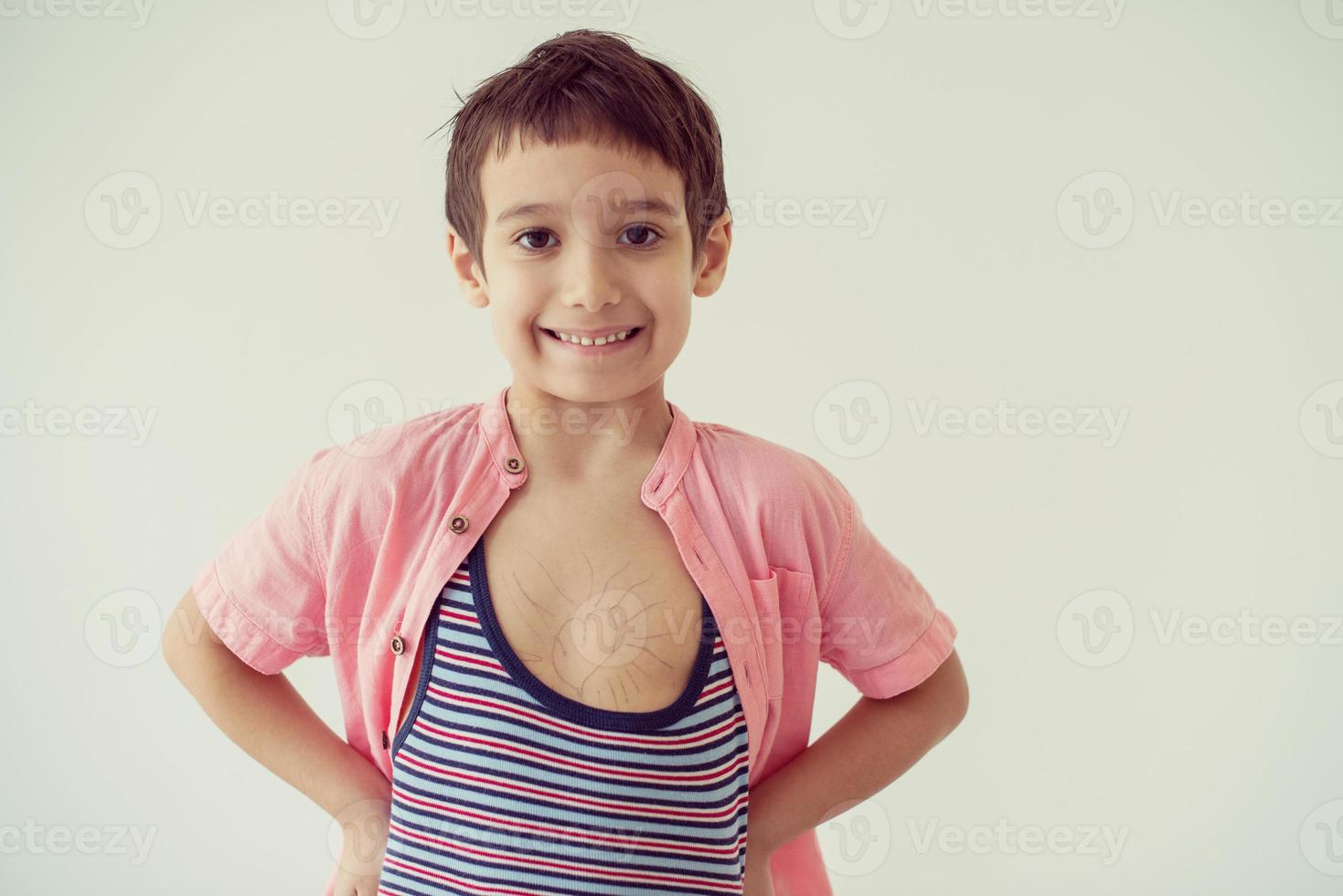 ragazzino guardando il simbolo di amore del cuore abbozzato sul petto foto