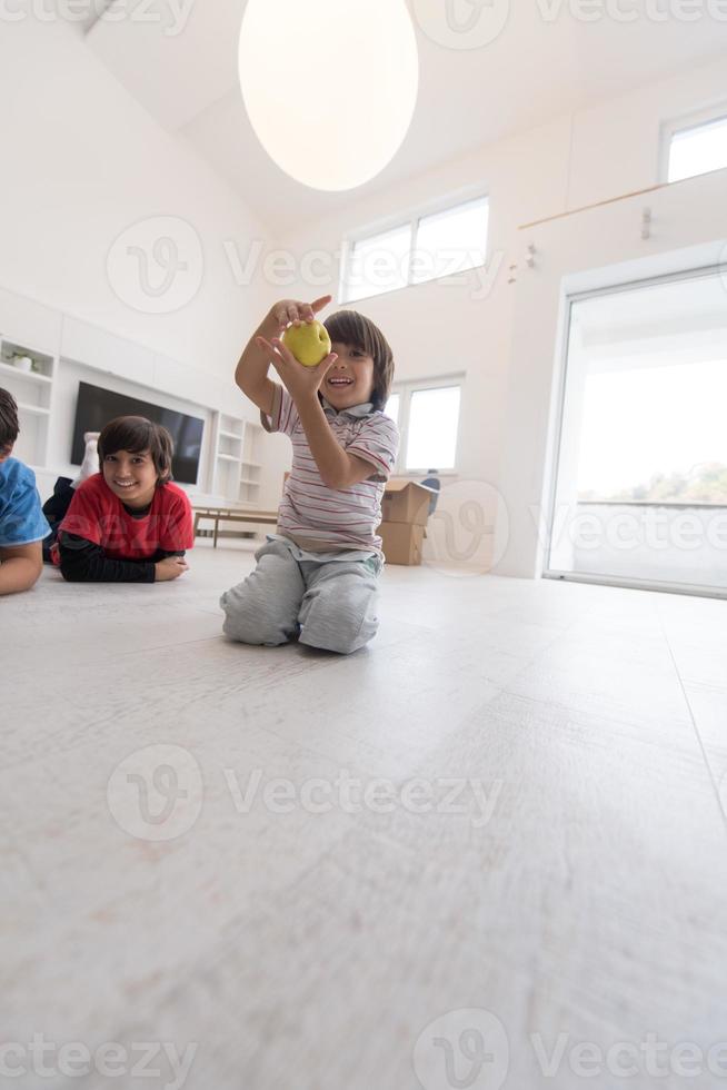 ragazzi che si divertono con una mela sul pavimento foto