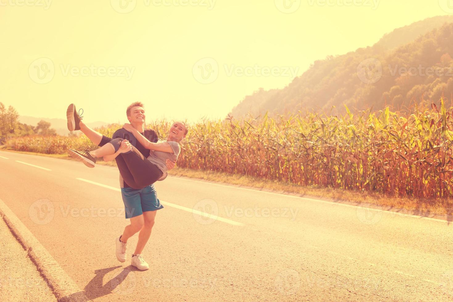 coppia felice jogging lungo una strada di campagna foto