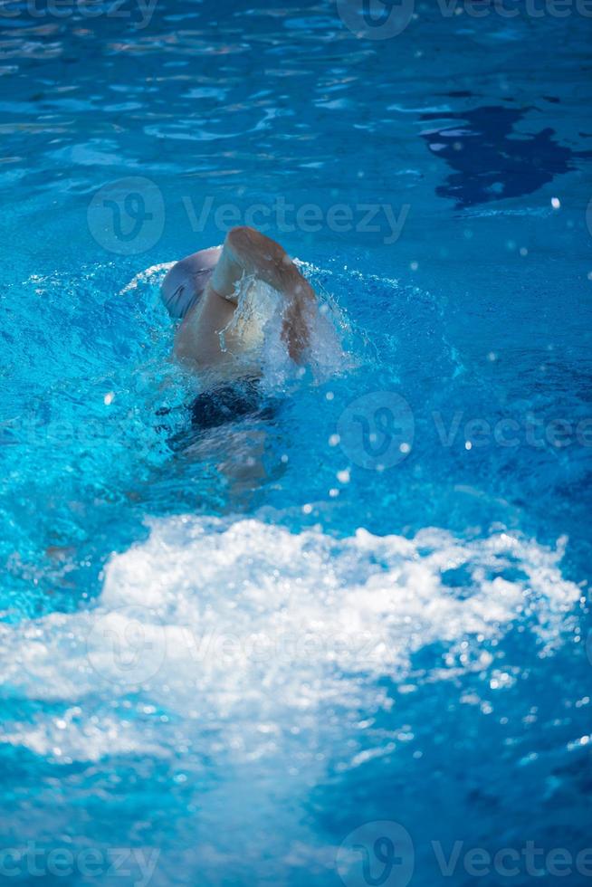 esercizio del nuotatore sulla piscina coperta foto