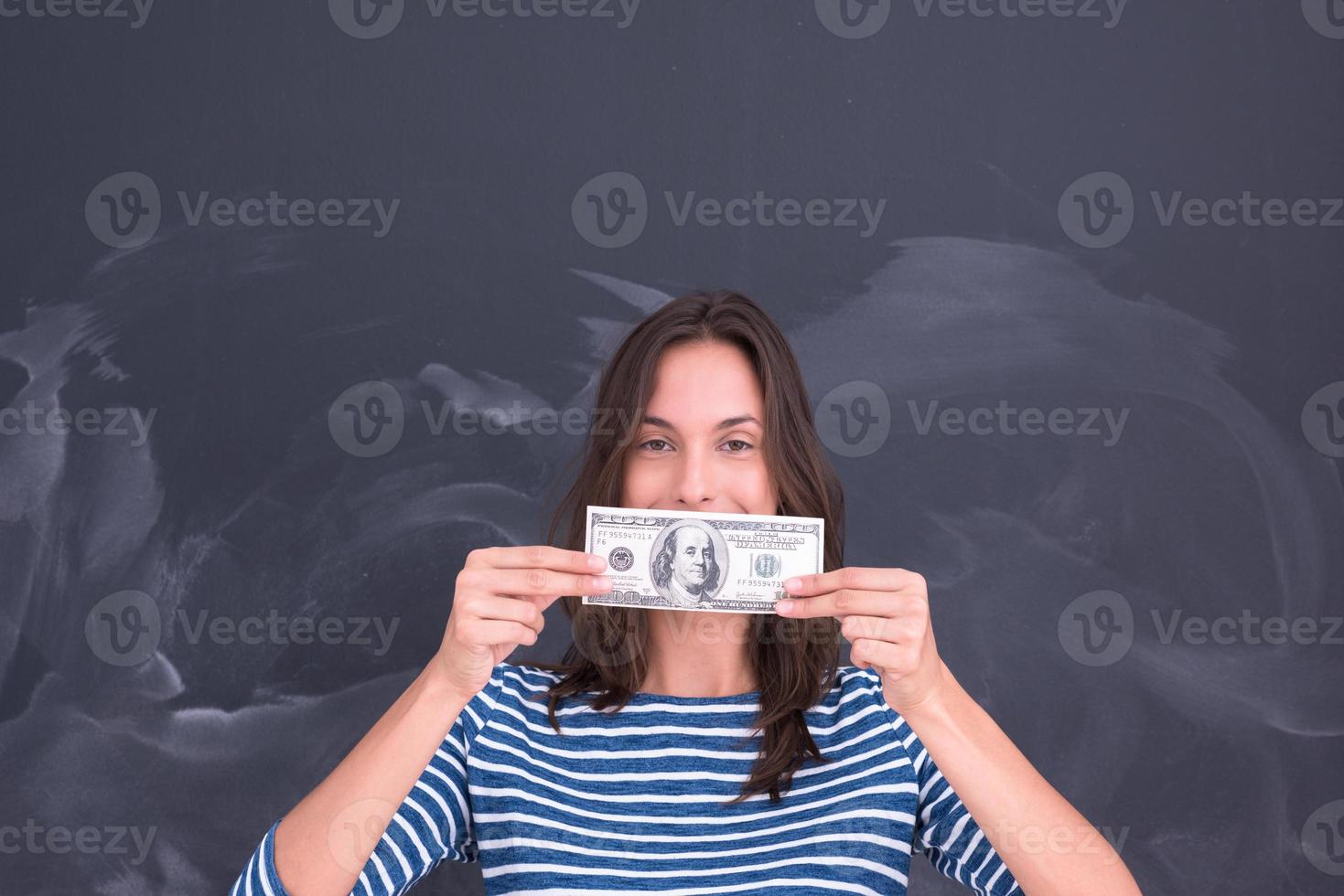 donna che tiene una banconota davanti al tavolo da disegno di gesso foto